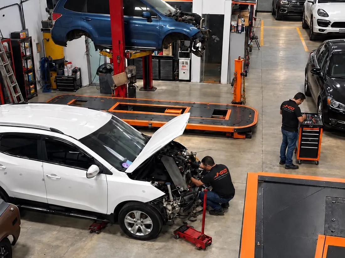 Bahías de trabajo de J-GO Auto Repair con vehículos en reparación y plataforma de enderezado