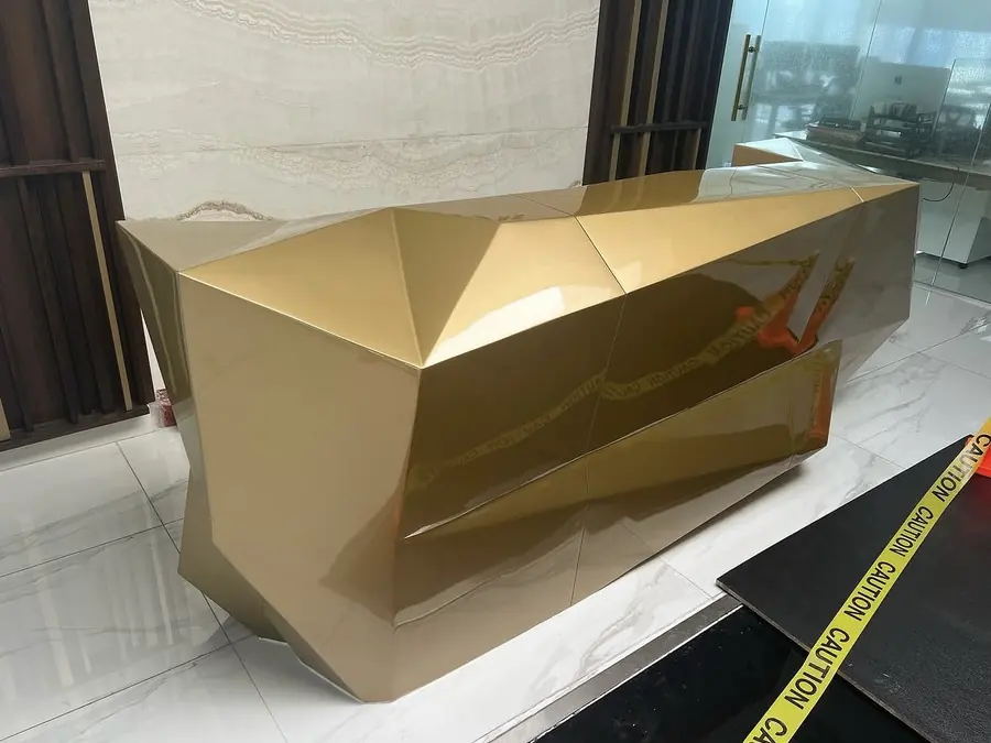 Escritorio facetado con acabado dorado espejo